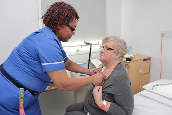 a member of staff is positioning the SensiumVitals® patch on patient’s chest