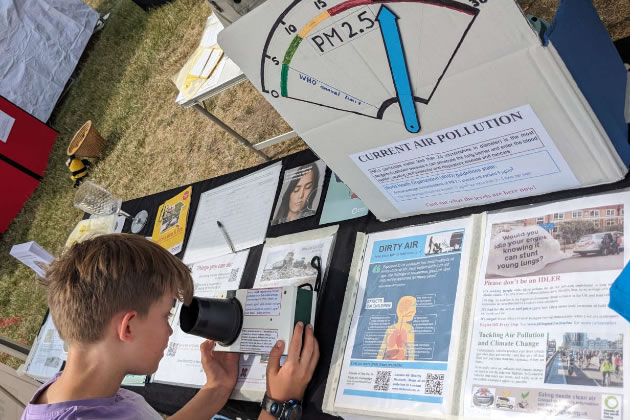 A young visitor to Ealing Friends of the Earth’s stall, takes a reading from the PM2.5 meter