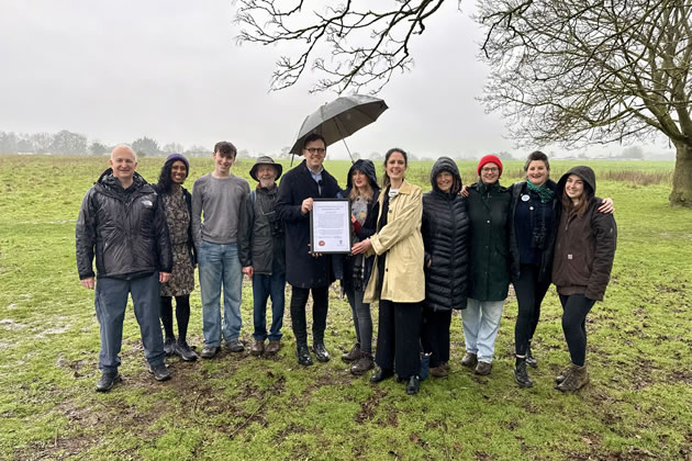 Ealing Council Leader Peter Mason (left) and Cabinet Member for Thriving Communities Blerina Hashani (right) present the Local Nature Reserve declaration to Katie Boyles, Chair of the Brent River Park charity (centre) and members of the Warren Farm Nature Reserve campaign. 
